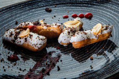 beyaz tepesi ve çikolata ile closeup dört taze eclairs