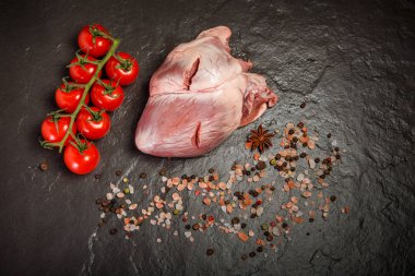 üst görünümü büyük domuz çiğ kalp baharat ve domates ile servis