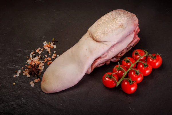 top view on raw pig tongue with spices and tomatoes cherry