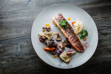 trendy dekore edilmiş kavrulmuş balık filetosu ve sebze üst görünümü