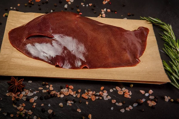 Gros foie de porc cru servi avec des épices et du romarin — Photo