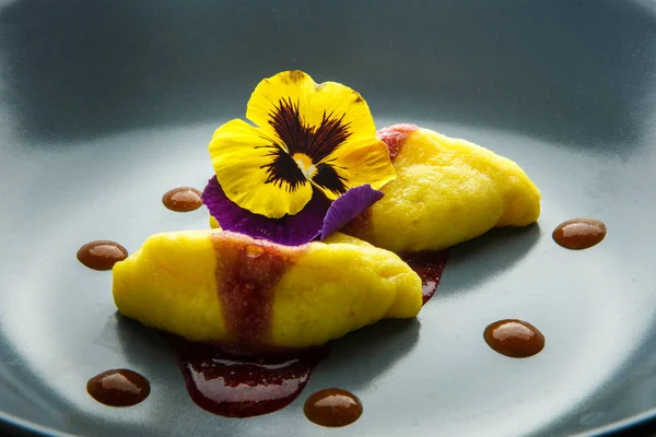 빨간 소스와 꽃을 곁들인 노란 만두 두 개 — 스톡 사진