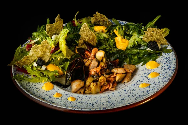 tasty restaurant appetizer of assorted seafood and salad leaves
