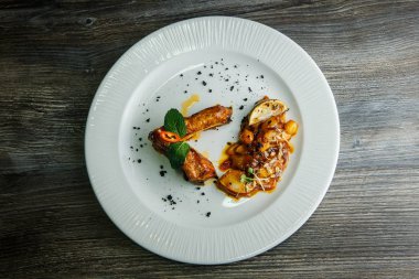 beyaz çanak üzerinde zarif dekore edilmiş pişmiş et üst görünümü