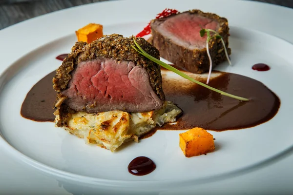 Primo piano finemente decorato semi-crudo pezzi di carne alla griglia con salsa — Foto Stock