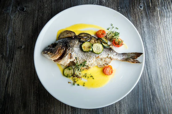 Вид сверху на вкусную рыбу с нарезанными овощами — стоковое фото
