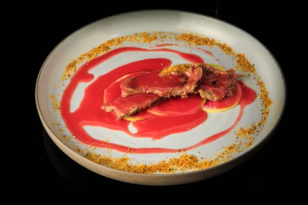 Irisan daging panggang lezat disajikan di bawah saus merah dan rempah-rempah — Stok Foto