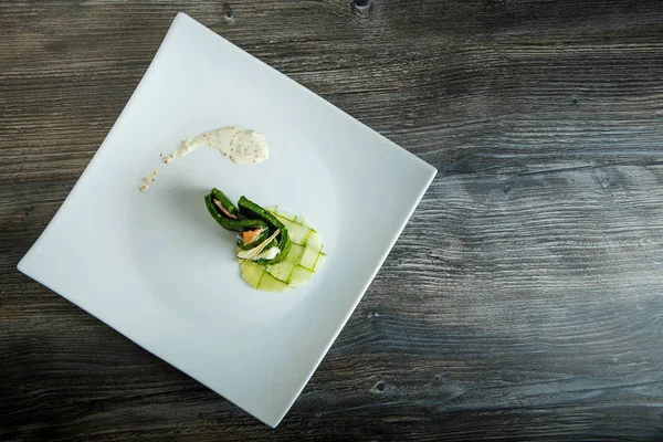 Draufsicht auf modernes Gericht aus Räucherlachs mit Käse in grüner Garnitur — Stockfoto