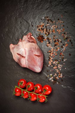 üst görünümü büyük domuz çiğ kalp baharat ve domates ile servis