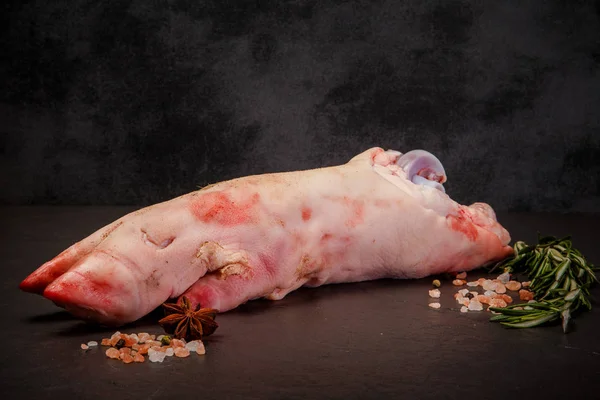 Большая сырая свиная нога с копытом, подается со специями и розмарином — стоковое фото