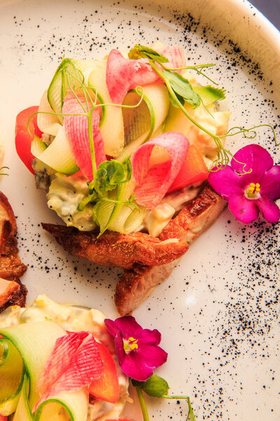 vertical top view on trendy potato salad with vegetables and meat