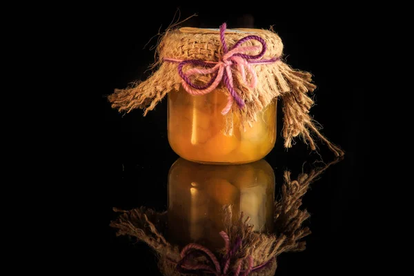 Маленькая стеклянная банка вкусного желтого фруктового варенья с отражением — стоковое фото