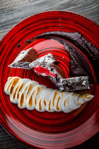 Vista vertical en sabroso pastel de brownie en rodajas con crema blanca al horno —  Fotos de Stock