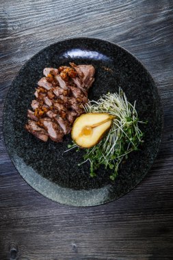 ızgara armut yarısı ile pişmiş sığır eti dilimleri üst görünümü