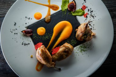 Üst manzara yakın modern restoran yemeği kavrulmuş bıldırcın bacağı.