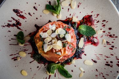 Üst görünüm, pekmezli, fındıklı ve naneli fırınlanmış elma.