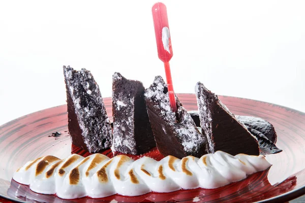 Closeup tasty sliced brownie cake with baked white cream — Stock Photo, Image