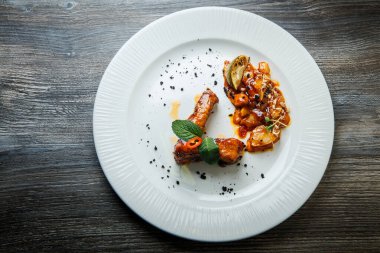 Beyaz tabakta ince dekore edilmiş et parçalarının üst görüntüsü