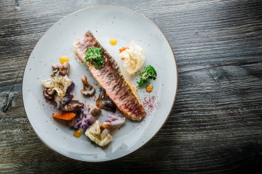 Enfes dekore edilmiş balık filetosu ve sebzelerin üst görüntüsü.