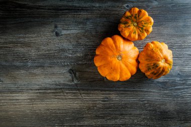 Tahta masada üç dekoratif sarı balkabağı.