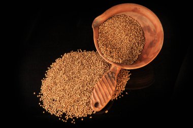 Toprak kasede ve yakınında kurumuş organik kişniş tohumlarının üst görüntüsü