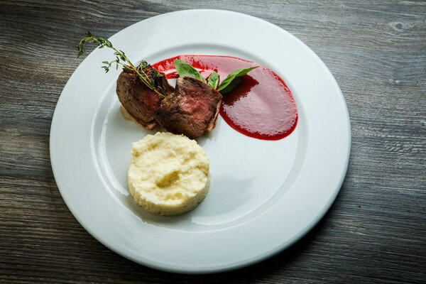 top view on tasty barbecued meat pieces with potato puree and sauce