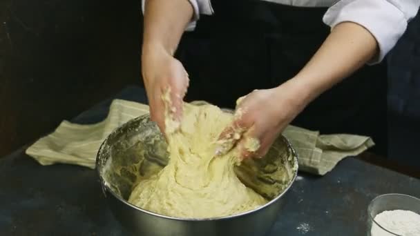 Detailní žena hnědá rukama měkké kvasinkové těsto ve velké hluboké kovové míse — Stock video