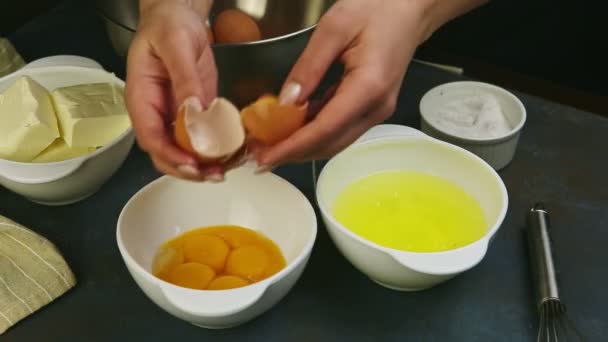 Närbild kvinna händer lagt separerade äggula från brutna råa ägg i vit skål — Stockvideo