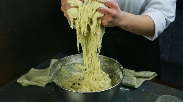 Il pasticcere da mani lentamente impasta la pasta morbida con uva passa in ciotola in metallo profonda grande — Video Stock