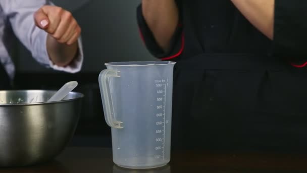 Close-up vrouw handen zetten slagroom van gebak zak op een andere vrouw hand — Stockvideo