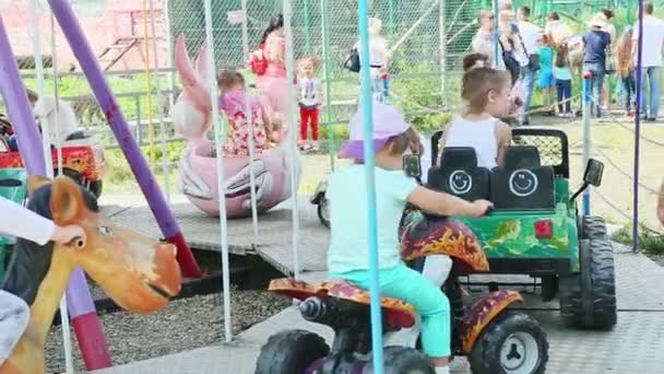 Dzieci gotowe do jazdy różnymi samochodami i konie na karuzeli w parku atrakcji — Wideo stockowe