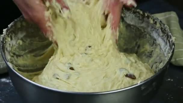 Macro view femme par les mains pétrir pâte à levure molle avec des raisins secs dans un bol en métal profond — Video