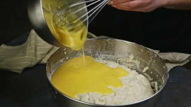 Closeup mãos femininas despeje gemas de ovo batidas em tigela de metal com massa de levedura — Vídeo de Stock