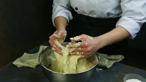 Nő szakács egyenruhában lassan gyúrja lágy tészta mazsolával nagy mély fém tál — Stock videók