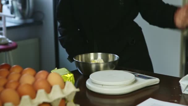 Mulher em uniforme chef coloca pequena tigela transparente em escalas de cozinha elétrica branca — Vídeo de Stock