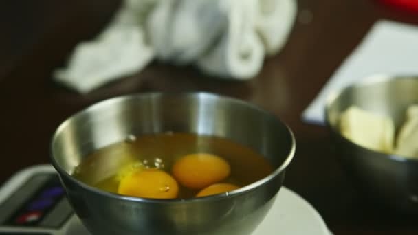 Gros plan femmes mains briser cru oeuf en métal bol debout sur écailles — Video