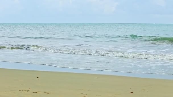 Pomalu panorama vpravo na klidném modrém oceánu s bílými vlnami tekoucími na zlaté pláži — Stock video