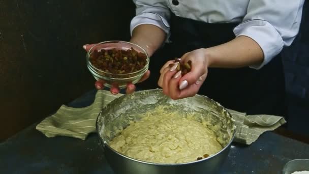 Slow motion van de vrouw handen klaar om rozijnen te gieten in zachte gist deeg — Stockvideo