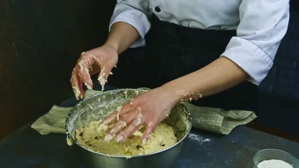 Cámara lenta de la mujer en uniforme de chef amasa masa de levadura suave con pasas — Vídeos de Stock