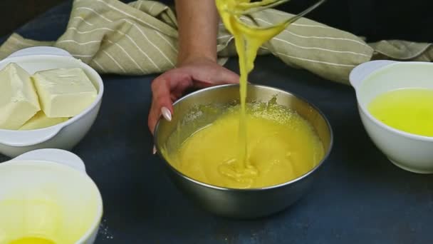 Mãos femininas de movimento lento por batedor misturando gemas de ovos crus com açúcar em tigela de metal — Vídeo de Stock