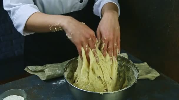 Donna al rallentatore in uniforme impasta lentamente con le mani pasta di lievito morbido con uvetta — Video Stock