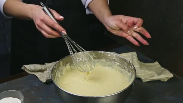 Detailní žena ruce míchání whisk tekuté droždí těsto ve velké hluboké kovové mísy — Stock video