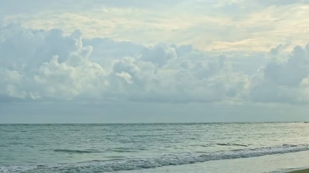 Αργά πανόραμα σε μεγάλα αφράτα σύννεφα επιπλέουν πάνω από τον γαλάζιο ωκεανό με λευκά κύματα — Αρχείο Βίντεο