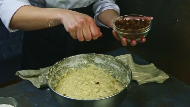 Il movimento lento di donna da mani prende l'uva passa e versa in pasta di lievito morbida — Video Stock
