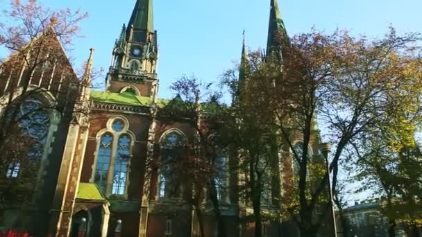 Rápidamente panorama desde el parque de otoño a la antigua iglesia catedral católica en Lviv, Ucrania — Vídeo de stock