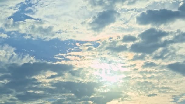 从明亮的隐藏的太阳到蓝天上巨大的蓬松的灰色云彩的缓慢的全景 — 图库视频影像