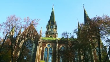 Ukrayna 'nın Lviv kentindeki açık mavi gökyüzüne karşı St. Olga ve Elizabeth katedrali üzerinde güvercinler uçar.