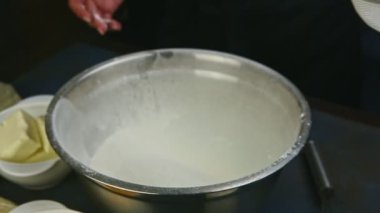 Ağır çekimde kadın ellerine yaklaş ve beyaz unlu derin metal kaseyi al.