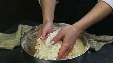 Kadının yavaş çekim gücü unu sıvı hamur ile karıştırıp metal kaseye koyuyor.