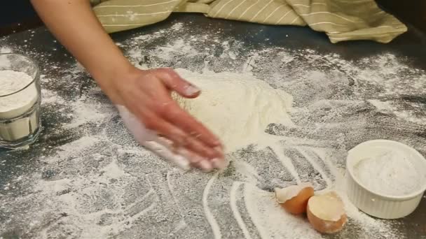 女性の手の動きが遅いテーブルの上に小麦粉の大きな山を形成小麦粉を振りかけた — ストック動画